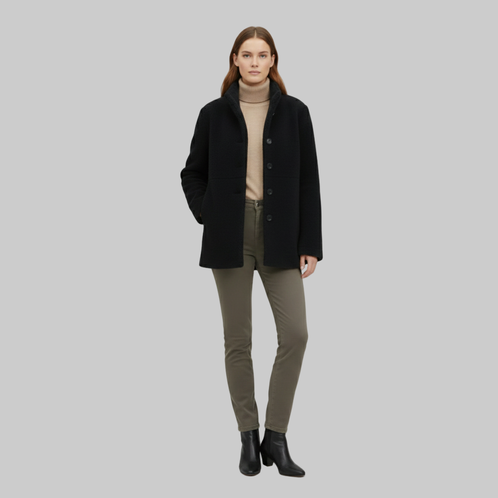 czarny wełniany płaszcz w połączeniu z beżowym golfem i wąskimi spodniami.
