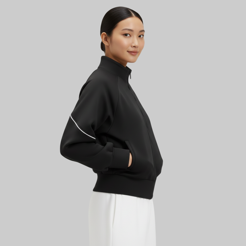 Wyobrażony profil kobiety w czarnej kurtce z wysokim kołnierzem, podkreślający czystą linię rękawa i zaokrągloną sylwetkę.