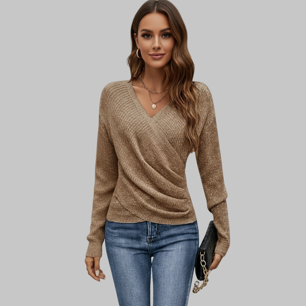 beżowy sweter z dekoltem w szpic w połączeniu z niebieskimi dżinsami, ujęcie z przodu.
