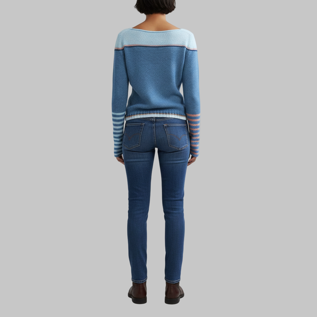 Widok z tyłu niebieskiego swetra damskiego z kolorowymi wstawkami, podkreślający prosty krój dzianiny.