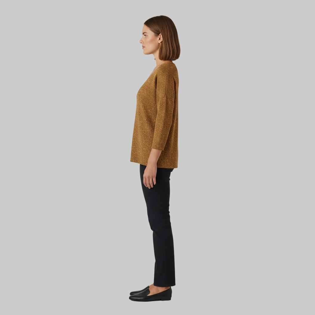 złoty sweter z błyszczącej dzianiny pokazany z boku.
