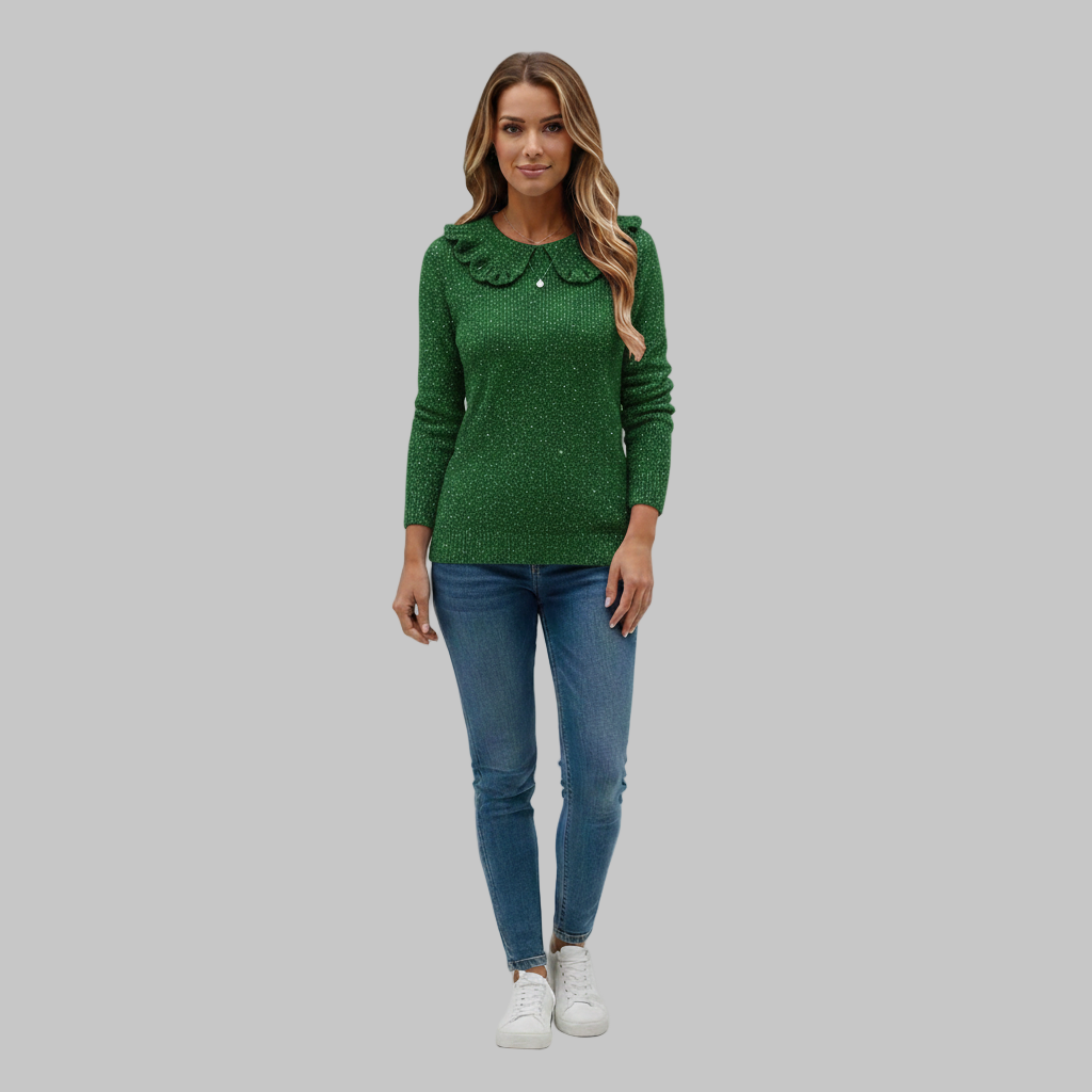 Zielony sweter damski z falistym kołnierzem, zestawiony z niebieskimi dżinsami i białymi trampkami.
