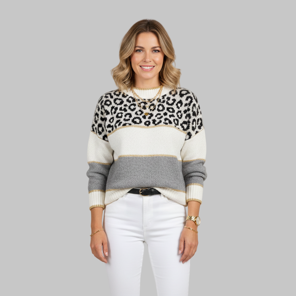Kobieta ubrana w szaro-biały sweter w paski z górną częścią w panterkę.
