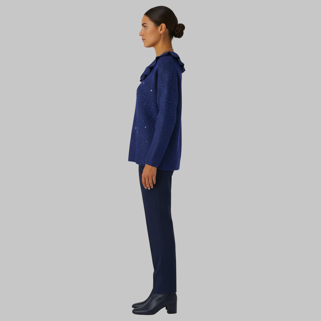 Widok z boku granatowego swetra z falbanami i dżinsów.
