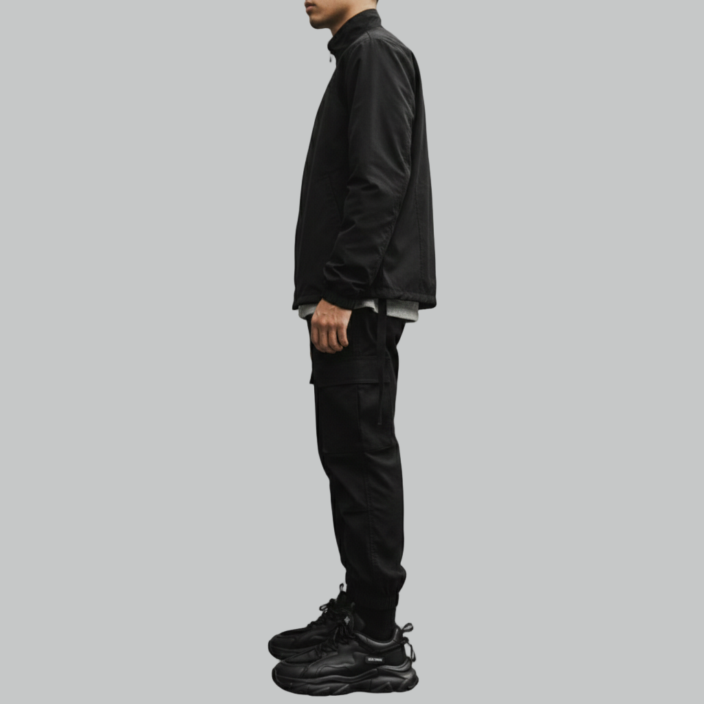 Wyobrażony profil boczny męskich czarnych grubych sneakersów, podkreślający grubą rzeźbioną podeszwę i wielowarstwową konstrukcję.